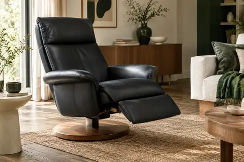 Fauteuil relax noir en revêtement synthétique, repose-pieds déployé et piètement rond en bois dans un salon lumineux.